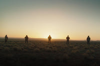 Community group photo in front of a sunset